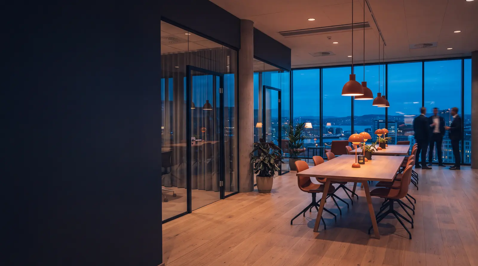 Moderne kontorlokaler i Oslo i skumringen, med møterom i glass og utsikt over byen og fjorden